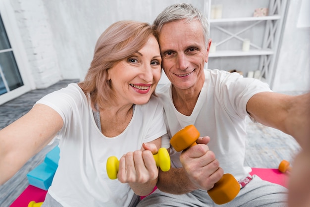 Close-up, de, alegre, amar, par velho, exercitar, com, dumbbells Foto gratuita