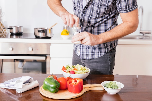 Close-up, de, um, mão homem, temperando, salada, com, fresco, mar sal, em, a, cozinha Foto gratuita