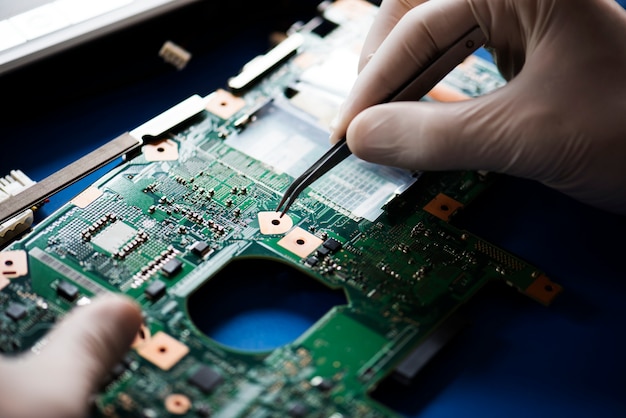 Closeup, de, mãos, com, computador, motherboard, e, pinça Foto Premium