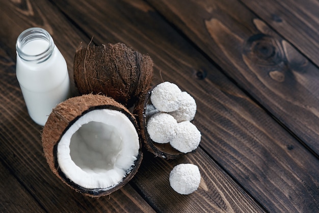 Cocos Com Doces Em Flocos De Coco E Garrafa De Leite Na Mesa De Madeira