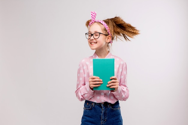 Colegial com óculos com um livro sorrindo Foto Premium