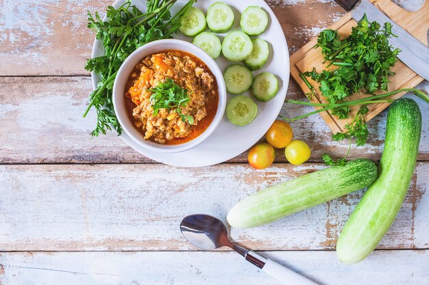 Comida tailandesa. pasta de pimentão de porco tailandês com pepino e legumes frescos Foto Premium