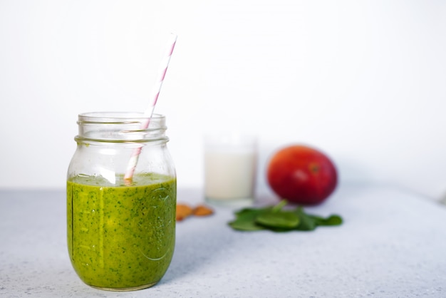 Componentes de smoothie de vitaminas green reach saudável com espinafre, manga, leite de amêndoa e morango Foto Premium