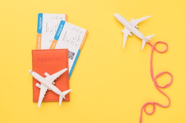 Composição de aviões com passaporte e bilhetes de avião rosa Foto gratuita