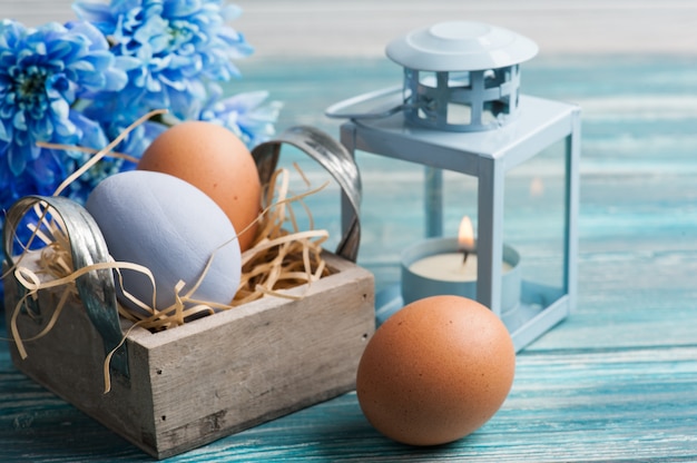 Composição de páscoa com ovos, flores azuis e velas Foto Premium