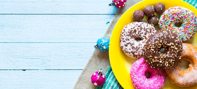 Composição de pequeno-almoço colorido donuts com estilos de cores diferentes Foto Premium
