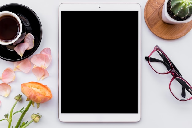 Composição do tablet moderno com café e flores Foto gratuita