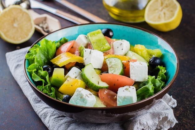 Conceito de lanche de comida saudável. salada grega tradicional com legumes frescos, queijo feta e azeitonas pretas Foto Premium