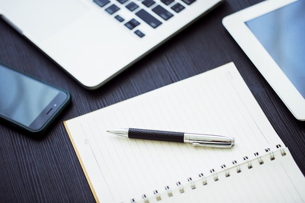 Conceito de negócio, no local de trabalho do escritório com o laptop na mesa de madeira contra as janelas Foto Premium