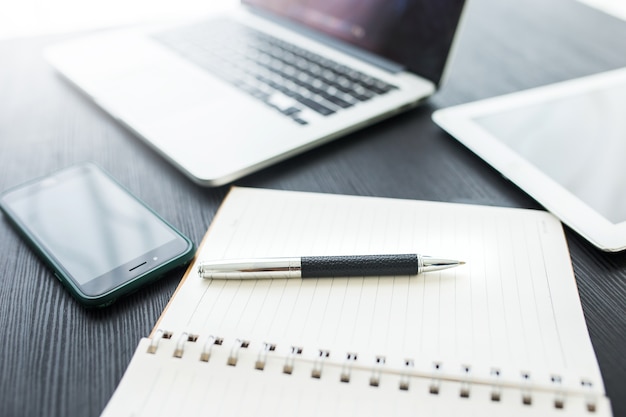 Conceito de negócio, no local de trabalho do escritório com o laptop na mesa de madeira contra as janelas Foto Premium