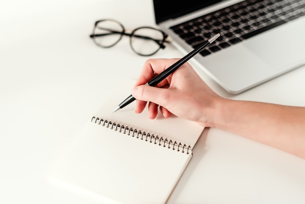 Conceito de negócio - trabalho em um escritório moderno brilhante com um laptop, notebook e óculos Foto Premium