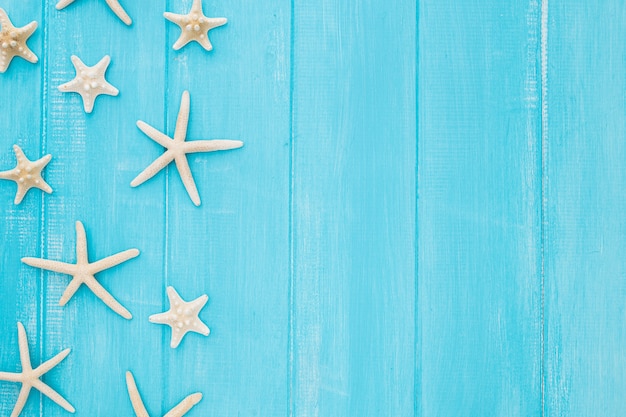 Conceito de verão com estrela do mar em um fundo azul de madeira com espaço de cópia Foto gratuita