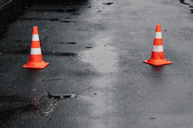 Cone de trânsito, com listras brancas e laranja no asfalto cinza Foto Premium