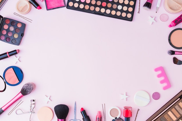 Conjunto de produtos cosméticos, formando o quadro no fundo rosa Foto gratuita