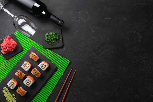 Conjunto de sushi e maki com uma garrafa de vinho na mesa de pedra. vista superior com espaço para texto Foto Premium