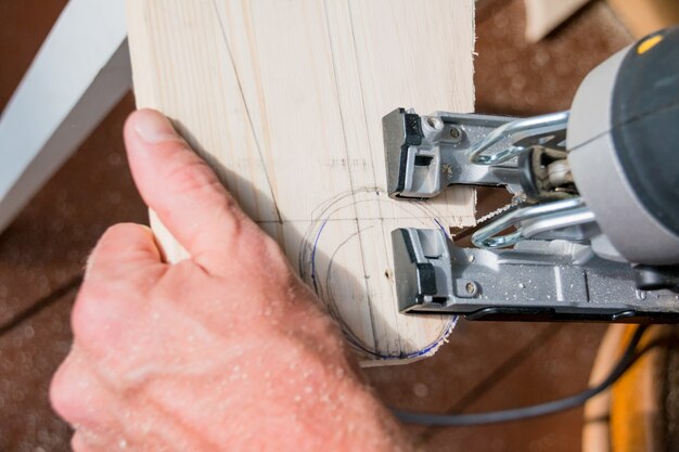 Construtor de carpinteiro de homem trabalhando com quebra-cabeças e wood.hobby conceito elétrico Foto Premium