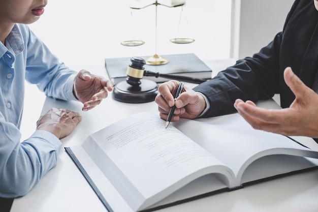Consulta e conferência de advogados masculinos e empresária profissional trabalhando e discussão tendo no escritório de advocacia no escritório. conceitos, de, lei, juiz, martelo, com, escalas, de, justiça Foto Premium
