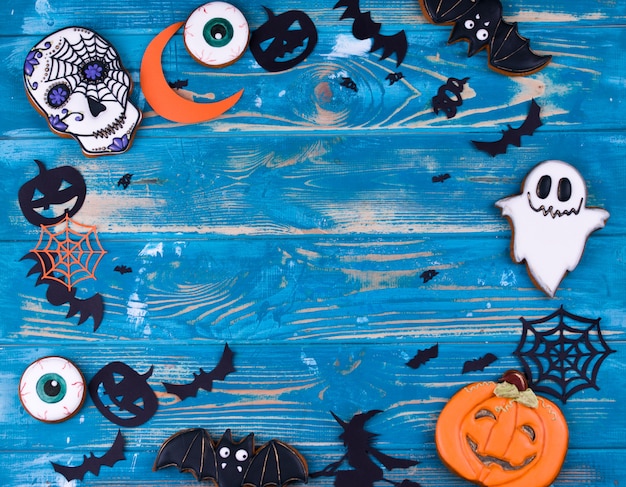Conteúdo da festa de halloween. biscoitos de gengibre de halloween sobre o fundo azul de madeira. Foto Premium