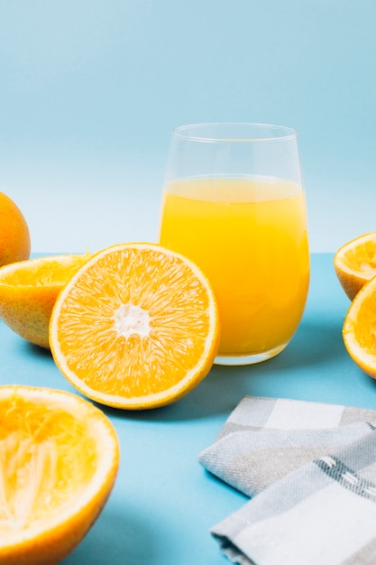 Copo com suco de laranja em fundo azul Foto gratuita