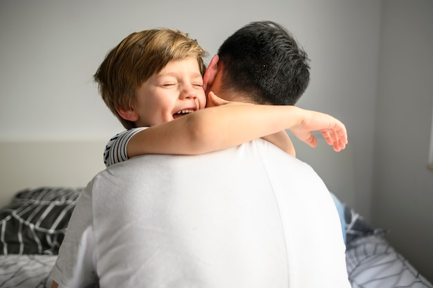 Criança Feliz Abraçando Seu Pai Foto Grátis 