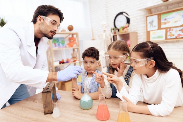 Crianças em conjunto com o professor para aulas de química. Foto Premium
