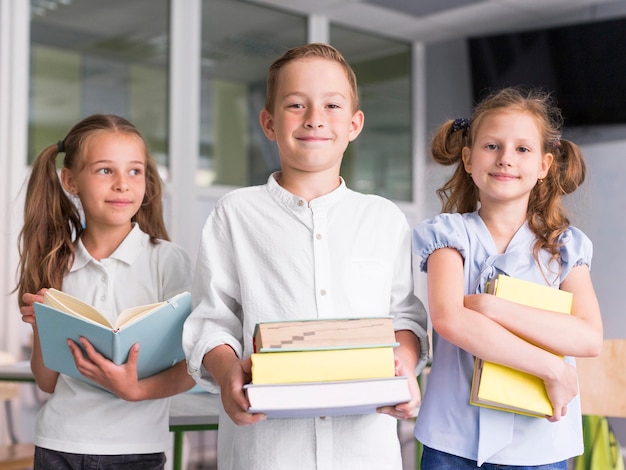 Crianças segurando livros na aula Foto Grátis