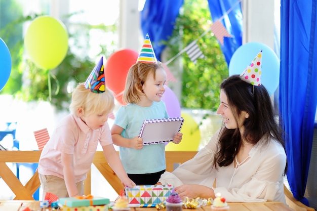 Criancinha e sua mãe comemoram a festa de aniversário com decoração colorida e bolos com decoração colorida e bolo Foto Premium