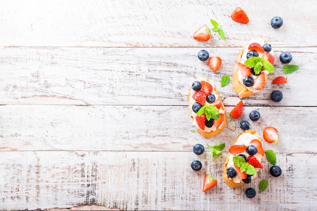 Crostini com baguete grelhado, cream cheese e frutas vermelhas Foto Premium