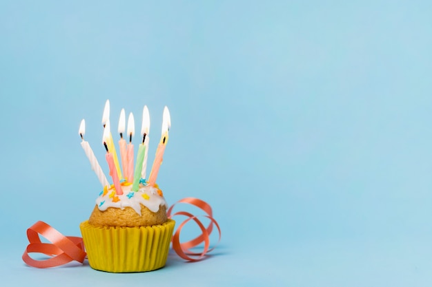 Cupcake com muitas velas acesas e espaço para texto Foto gratuita