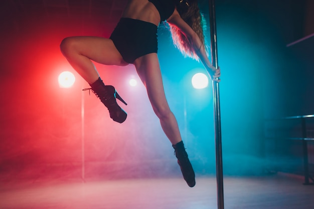 Dançarina de strip-tease jovem movendo-se em sapatos de salto alto ...