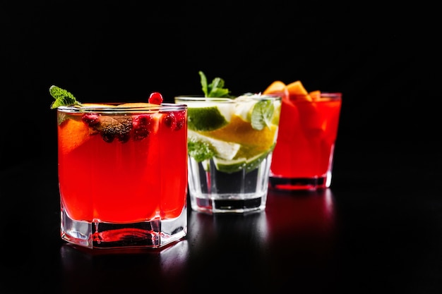 Delicioso mojito, rum e coca-cola, laranja-sangue e coquetéis de vodka servidos com frutas Foto gratuita