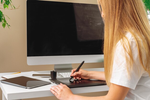 Designer de mulher trabalhando no escritório e usando um tablet gráfico Foto Premium