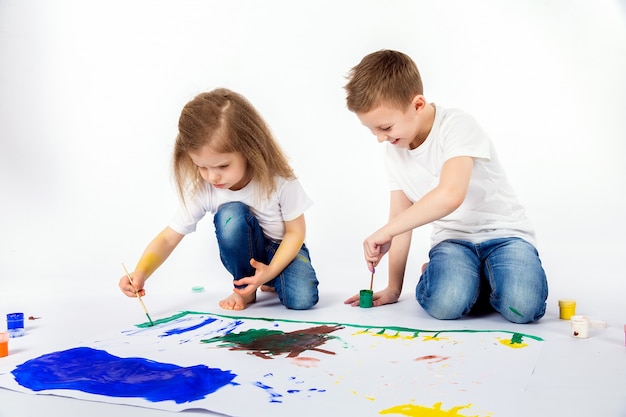 Dois amigos bonitos da criança menino e menina estão desenhando pinturas Foto Premium