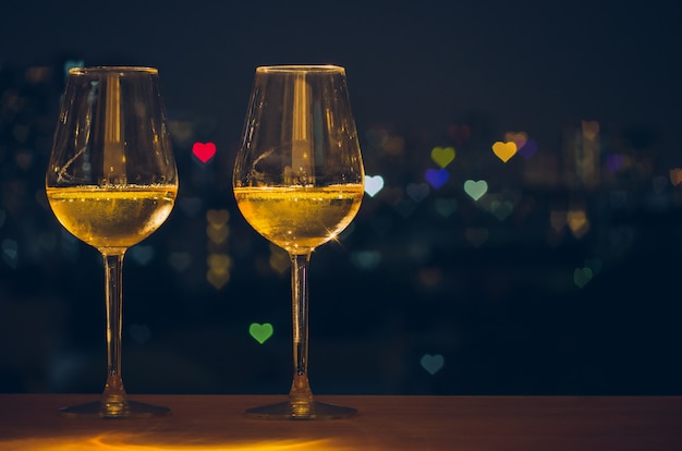 Dois copos de vinho branco na mesa de madeira do bar no terraço Foto Premium