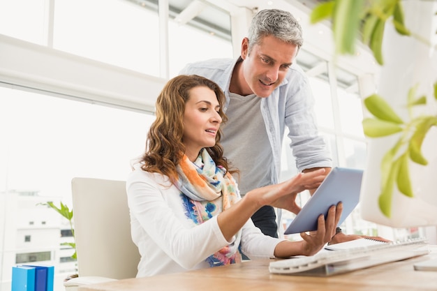 Dois designers casuais trabalhando com tablet no escritório Foto Premium