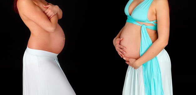 Duas Mulheres Grávidas Mostrando Suas Lindas Barrigas Isoladas Em Um Fundo Preto Foto Premium 