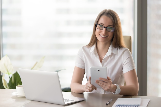 Empreendedor feminino usando tablet digital no escritório Foto gratuita