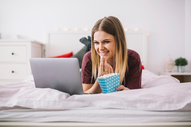 Encantadora Mulher Assistindo Filme No Laptop Foto Grátis