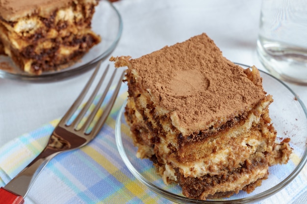 Endureça o tiramisu em uma placa com um copo do chá no fundo. Foto Premium