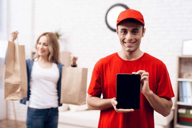 Entregador árabe com tablet e menina com packege Foto Premium