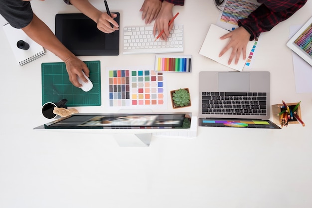 Equipe dos designer gráficos que trabalham em um computador no estúdio criativo do projeto da ocupação dos officeideas, local de trabalho do artista com vista superior. Foto Premium