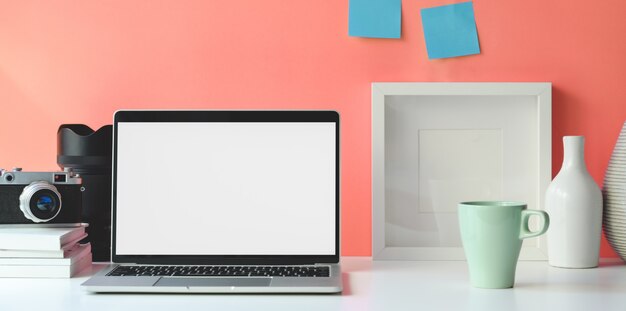 Espaço de trabalho mínimo com o computador portátil de tela em branco aberta Foto Premium