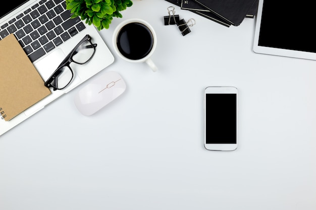 Espaço de trabalho no escritório com tablet e smartphone com telas vazias em branco. Foto Premium