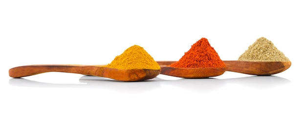 Especiarias indianas em colheres de madeira Foto Premium