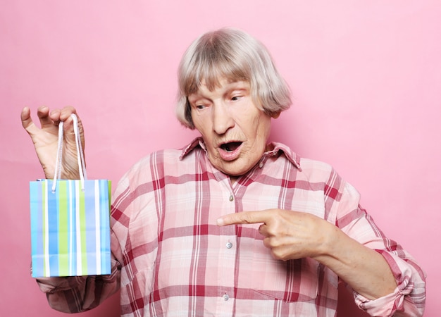 Estilo de vida e conceito de pessoas de mulher feliz sênior com sacola de compras sobre rosa Foto Premium