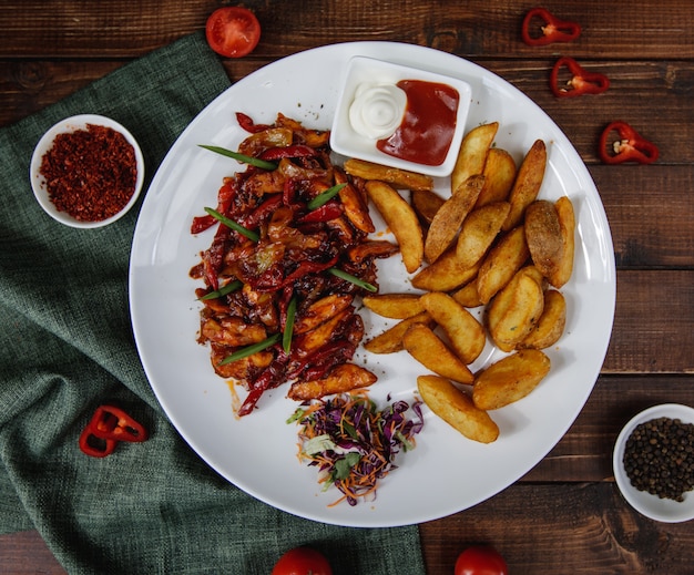 Fajitas de frango com batatas assadas servidas com molhos e salada Foto gratuita