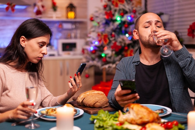 Família feliz comendo um jantar delicioso sentado à mesa de jantar