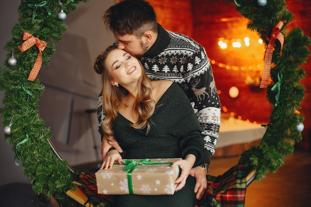 Família fofa sentado perto da árvore de natal Foto gratuita