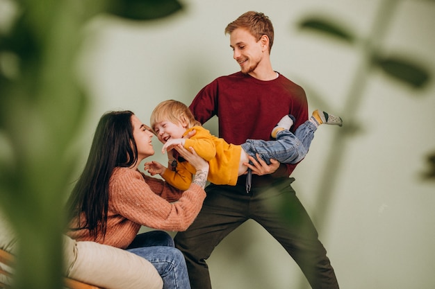 Família jovem com filho pequeno sentado na cadeira Foto gratuita