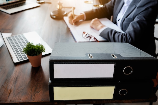 Feche acima do homem de negócios do advogado que trabalha ou que lê o lawbook no local de trabalho do escritório para o conceito do advogado do consultante. Foto Premium